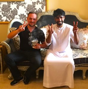 Mark and Sultan smiling and showing the peace sign